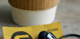 Which Wireless Earbuds Offer the Best Value in 2025? Blurry earbuds on crumpled SEPTA ticket, spilled coffee, cheesesteak keychain.